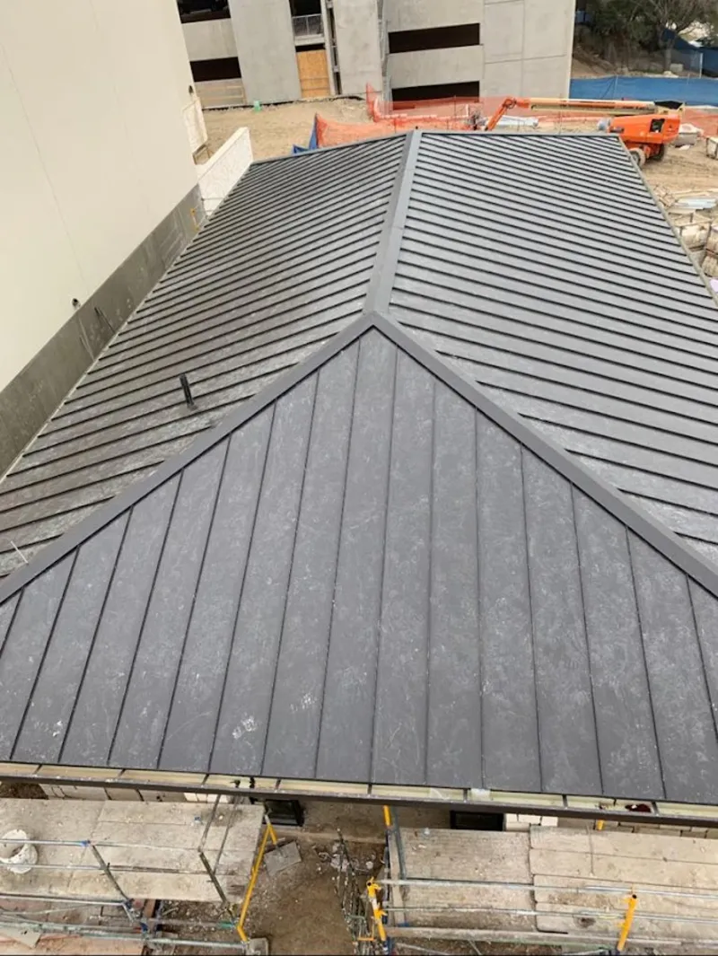 Commercial metal roof construction with crane equipment in Valley